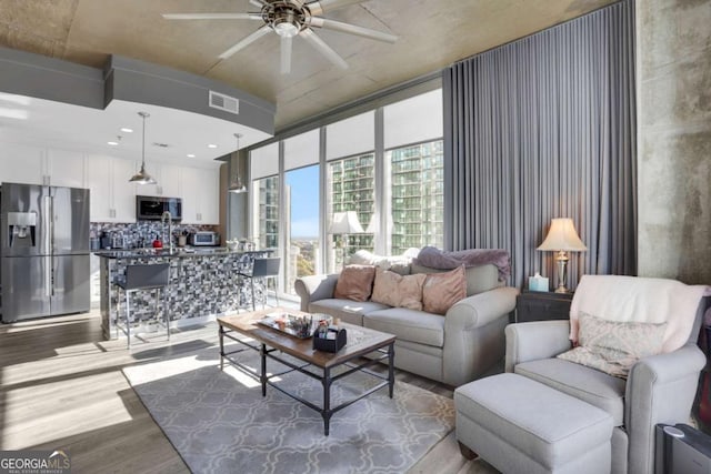 living room with ceiling fan and light hardwood / wood-style floors