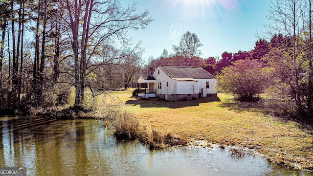 exterior space featuring a lawn and a water view