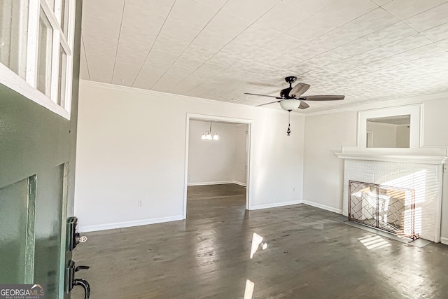 unfurnished living room featuring a fireplace, ceiling fan with notable chandelier, and crown molding