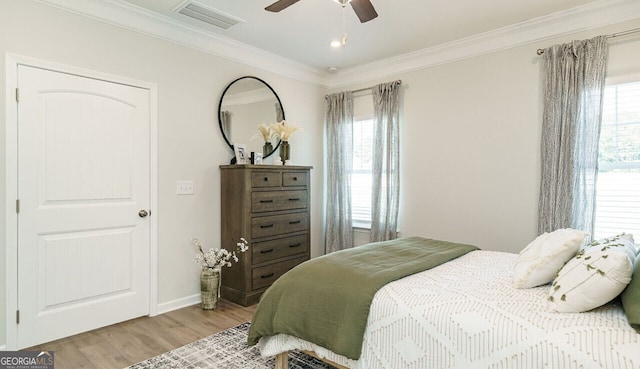 bedroom featuring ceiling fan, light wood-type flooring, and ornamental molding