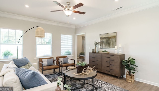 sitting room featuring ceiling fan, ornamental molding, and light wood-type flooring