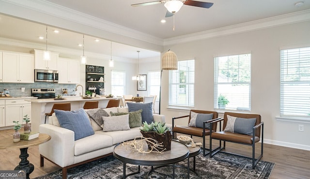 living room featuring dark hardwood / wood-style floors, plenty of natural light, ceiling fan, and crown molding