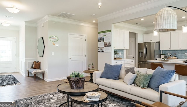 living room with hardwood / wood-style flooring and ornamental molding