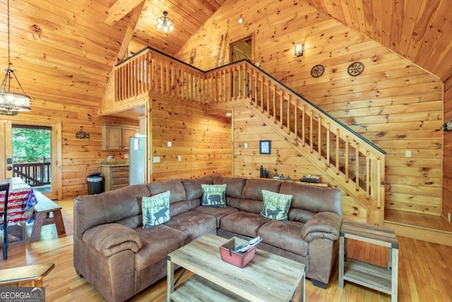 living room featuring wood walls, high vaulted ceiling, wood ceiling, and light wood-type flooring