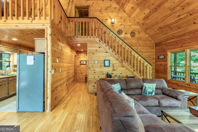 living room featuring sink, wooden ceiling, and wood walls