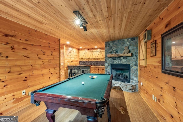 recreation room featuring a stone fireplace, wood ceiling, wood walls, and billiards