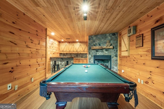 recreation room featuring wood walls, a stone fireplace, wooden ceiling, and pool table