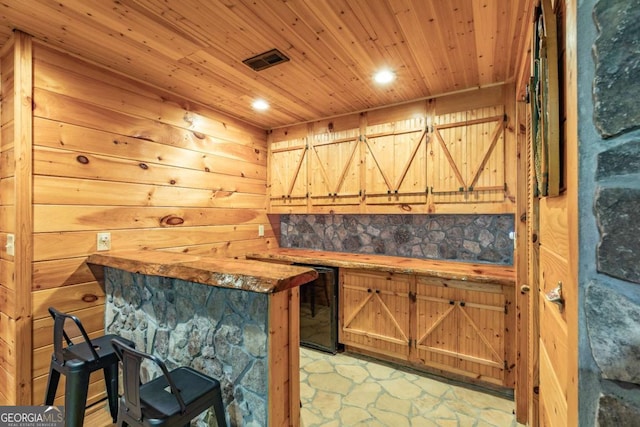 bar featuring butcher block countertops, wooden walls, and wood ceiling