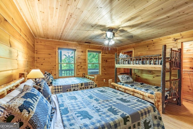 bedroom with wood walls, ceiling fan, wood ceiling, and hardwood / wood-style flooring