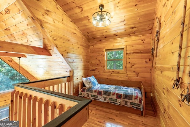 bedroom with wooden walls, light hardwood / wood-style floors, multiple windows, and wooden ceiling