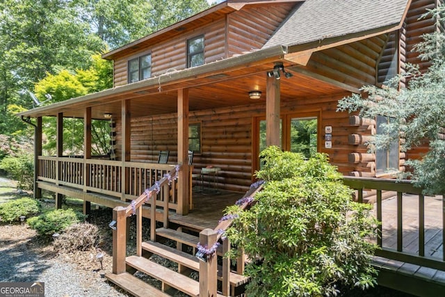 property entrance featuring a wooden deck and covered porch