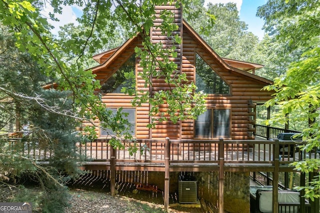 rear view of property with a wooden deck and cooling unit