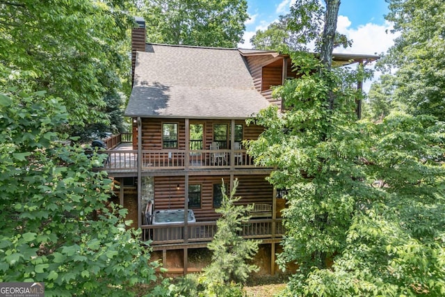 rear view of house featuring a wooden deck