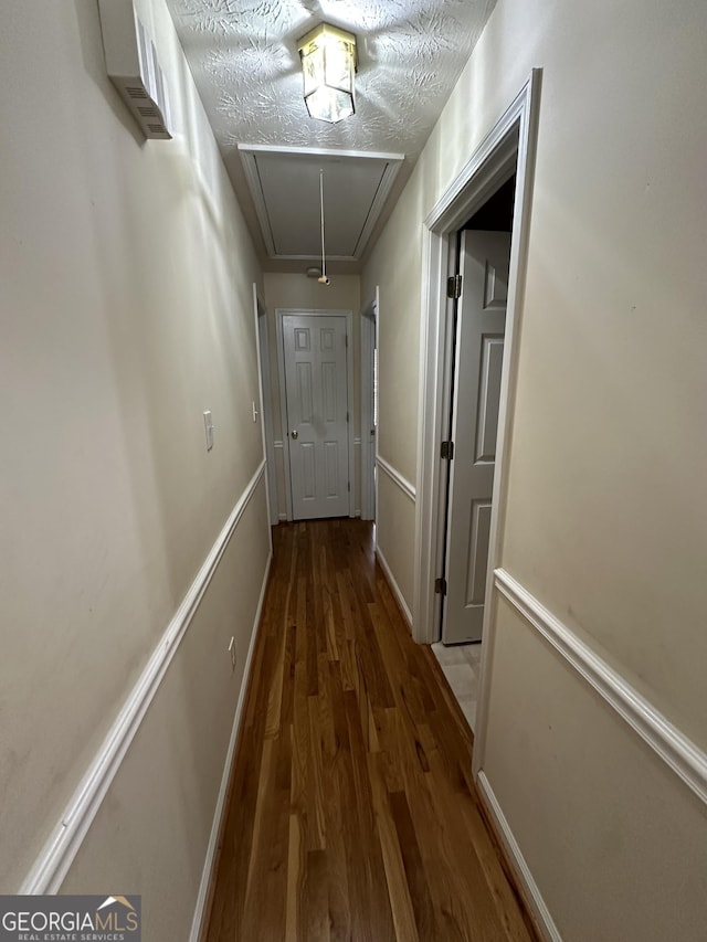 hall featuring dark hardwood / wood-style floors and a textured ceiling