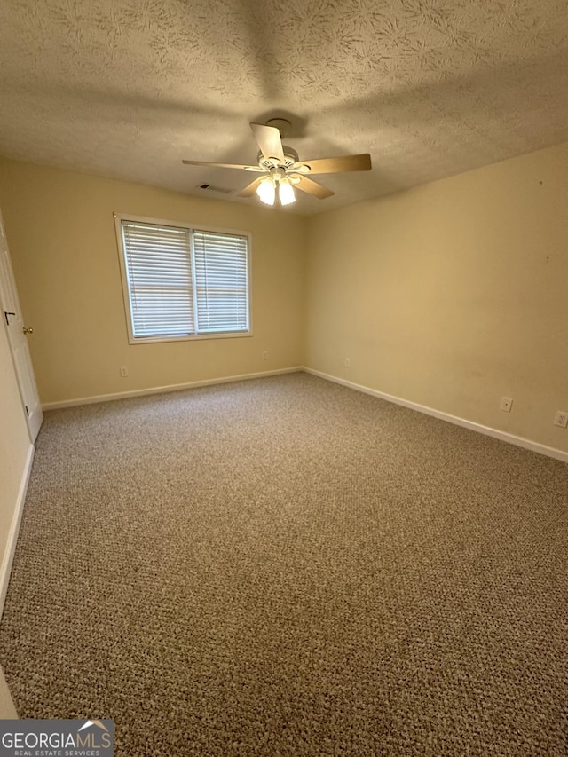 carpeted spare room with ceiling fan and a textured ceiling