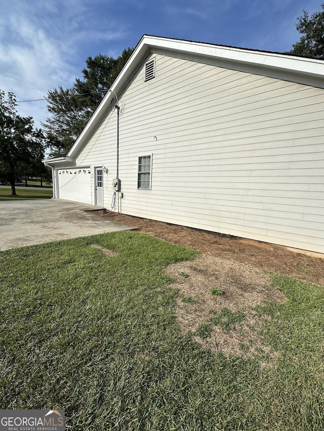 view of side of property with a yard and a garage