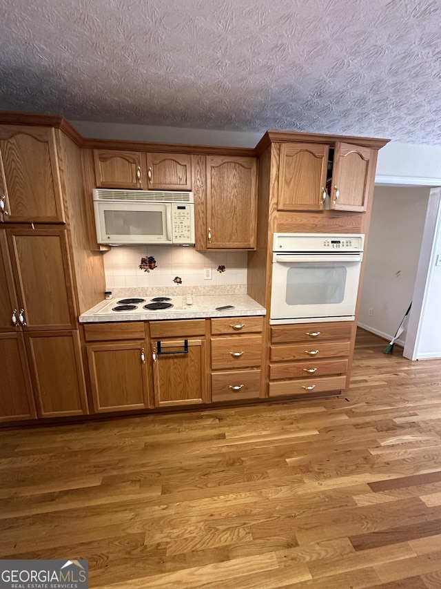 kitchen with light hardwood / wood-style floors and white appliances