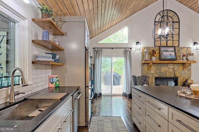 kitchen with a fireplace, wood ceiling, sink, decorative light fixtures, and white cabinets