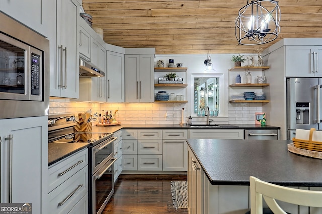 kitchen with backsplash, range hood, appliances with stainless steel finishes, white cabinetry, and wood ceiling