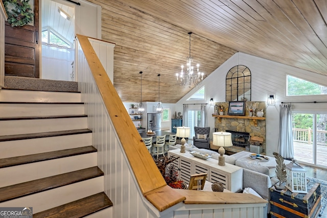 living room with a stone fireplace, wooden ceiling, high vaulted ceiling, and a chandelier