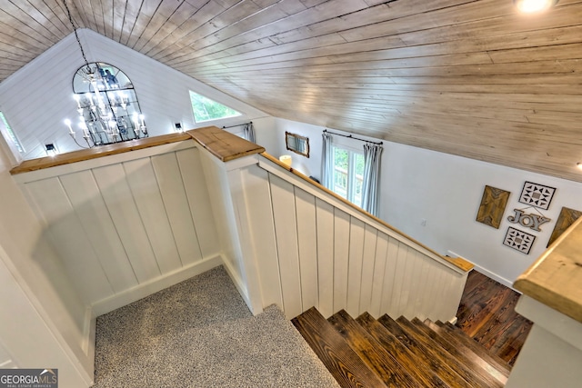 stairway featuring carpet flooring, lofted ceiling, wood ceiling, and a notable chandelier