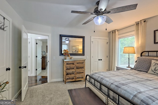 carpeted bedroom with ceiling fan and a closet