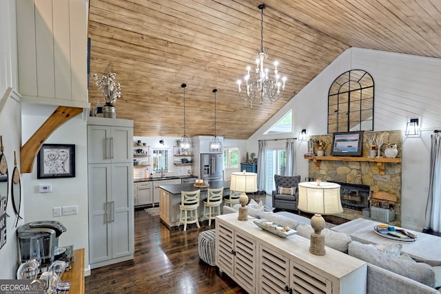 living room with dark hardwood / wood-style flooring, high vaulted ceiling, wooden ceiling, a chandelier, and a stone fireplace