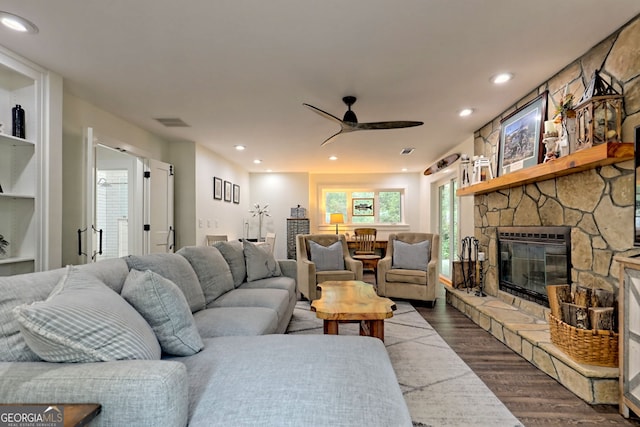 living room with a stone fireplace, ceiling fan, and hardwood / wood-style floors