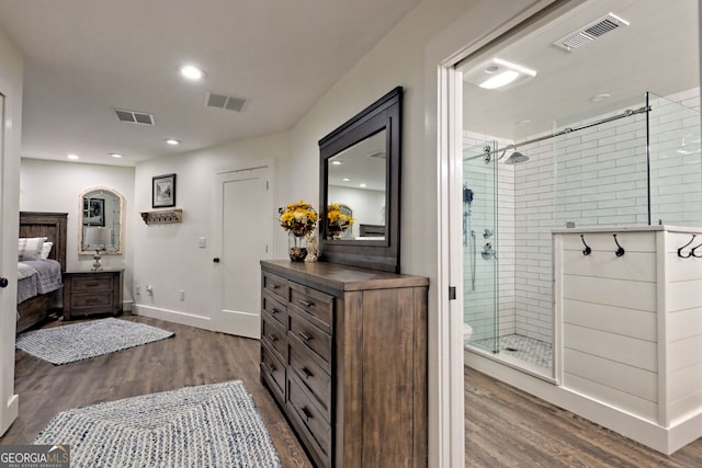 bathroom with a shower with door, vanity, and wood-type flooring