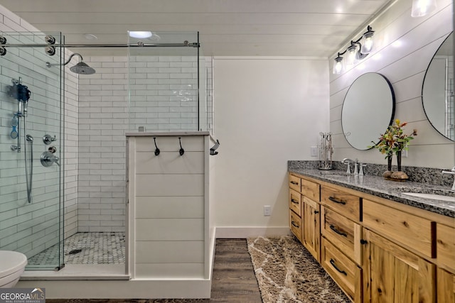 bathroom with toilet, vanity, an enclosed shower, and hardwood / wood-style flooring