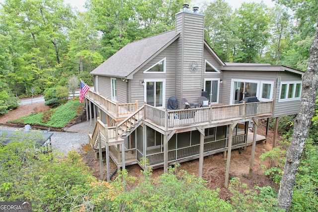 rear view of house with a deck and a sunroom