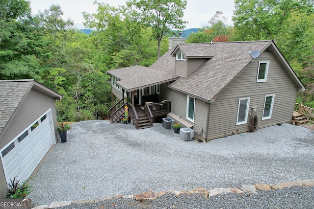 view of front of home with central AC unit and a garage