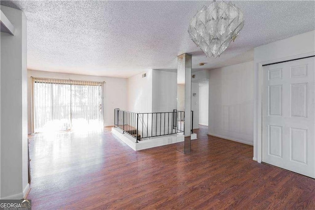 empty room featuring dark hardwood / wood-style flooring and a textured ceiling