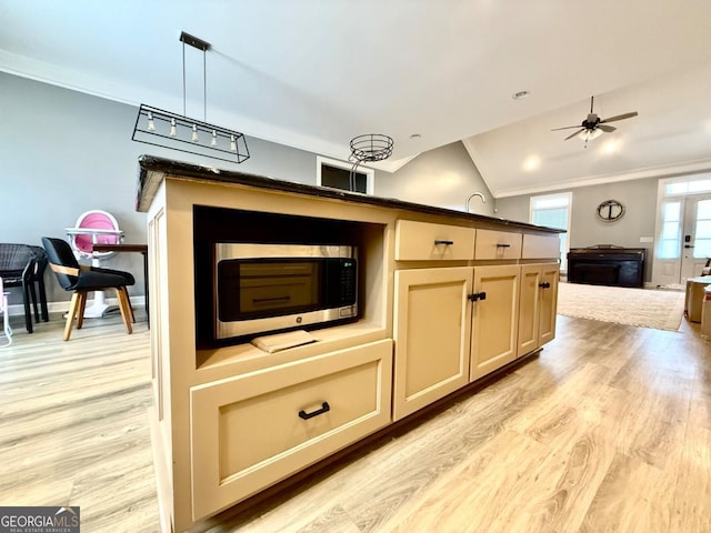 kitchen with pendant lighting, ceiling fan, light hardwood / wood-style floors, and vaulted ceiling