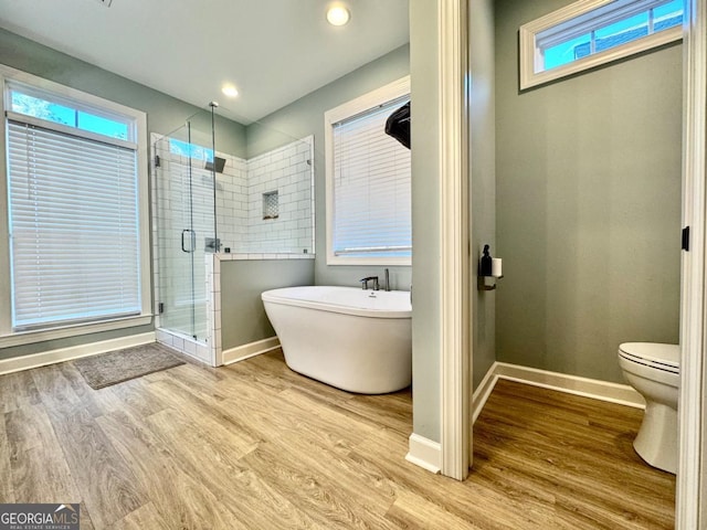 bathroom with plus walk in shower, hardwood / wood-style floors, and toilet