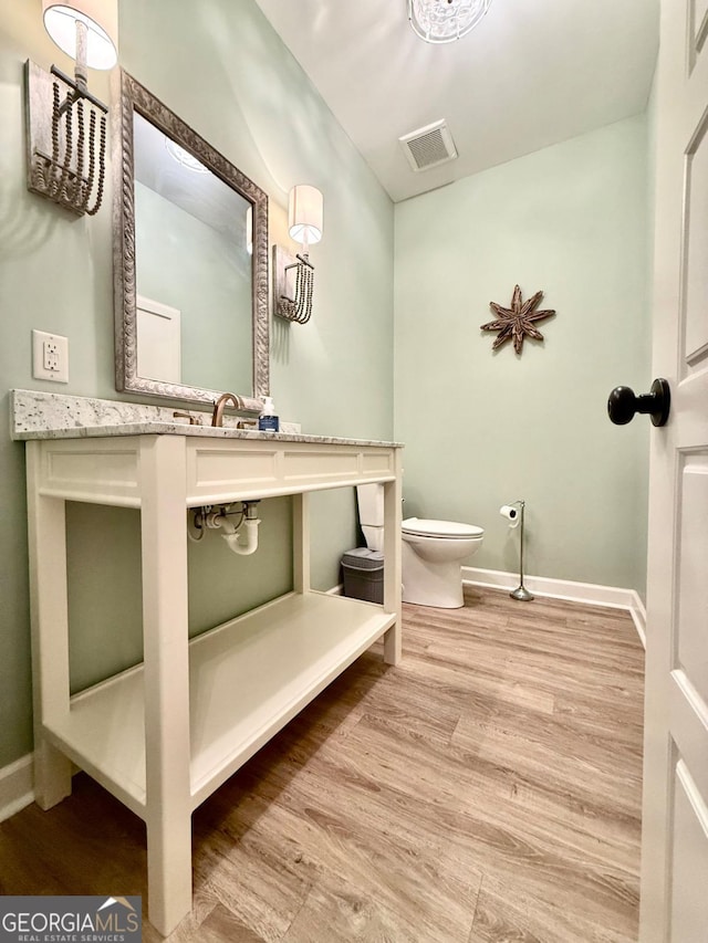 bathroom featuring hardwood / wood-style floors and toilet