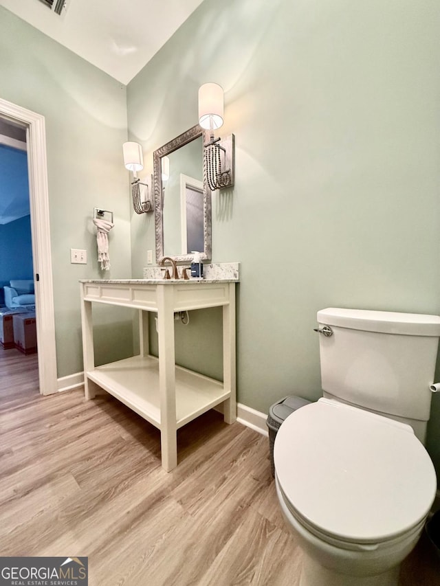 bathroom featuring hardwood / wood-style floors and toilet