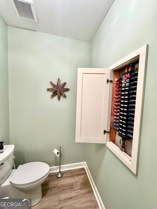 bathroom featuring wood-type flooring and toilet