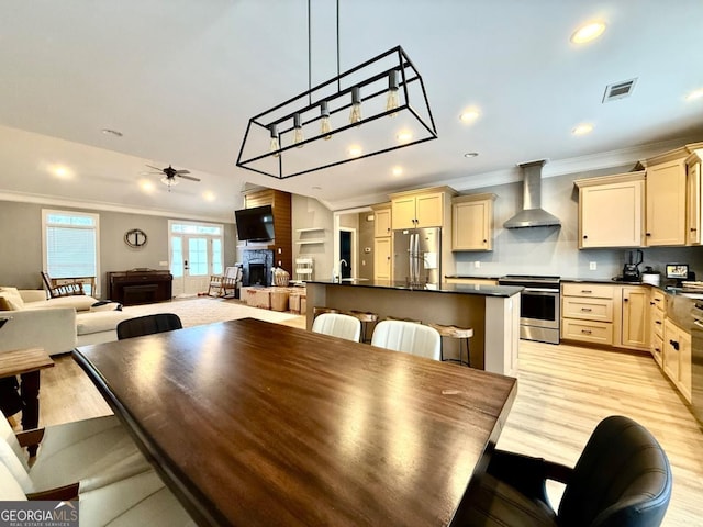 dining room featuring ceiling fan, sink, crown molding, and light hardwood / wood-style flooring