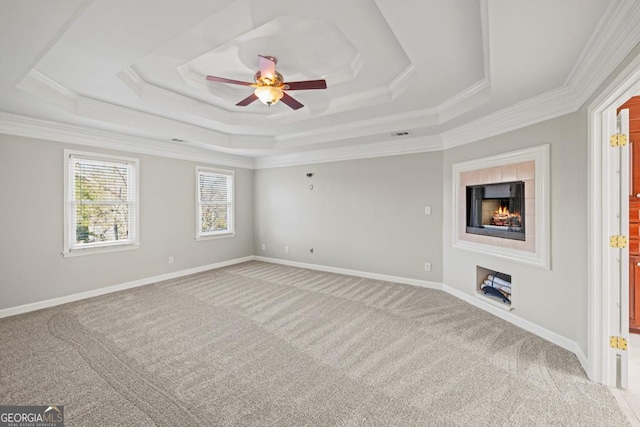 carpeted empty room featuring a tray ceiling, ceiling fan, and ornamental molding