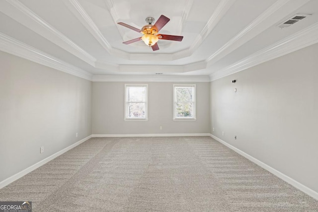 empty room featuring ceiling fan, carpet floors, crown molding, and a tray ceiling