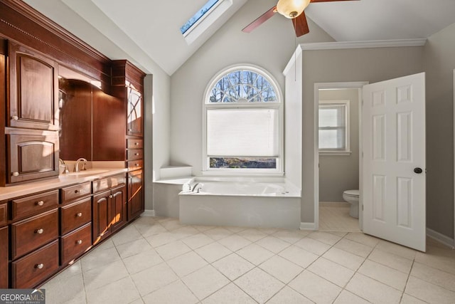 bathroom with tile patterned floors, vaulted ceiling, ceiling fan, toilet, and a tub