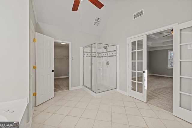 bathroom with tile patterned floors, a shower with door, and french doors