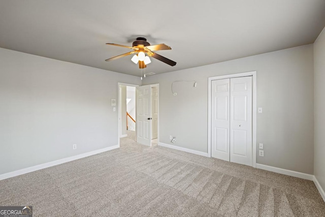 unfurnished bedroom with carpet flooring, ceiling fan, and a closet