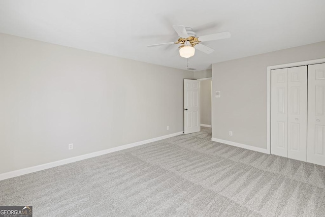 unfurnished bedroom with ceiling fan, light carpet, and a closet