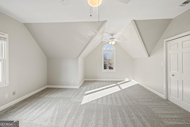 additional living space featuring light colored carpet, vaulted ceiling, and ceiling fan