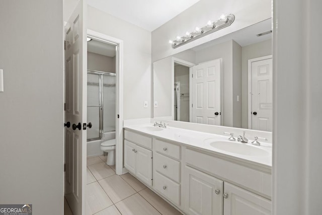 full bathroom featuring toilet, tile patterned flooring, vanity, and combined bath / shower with glass door