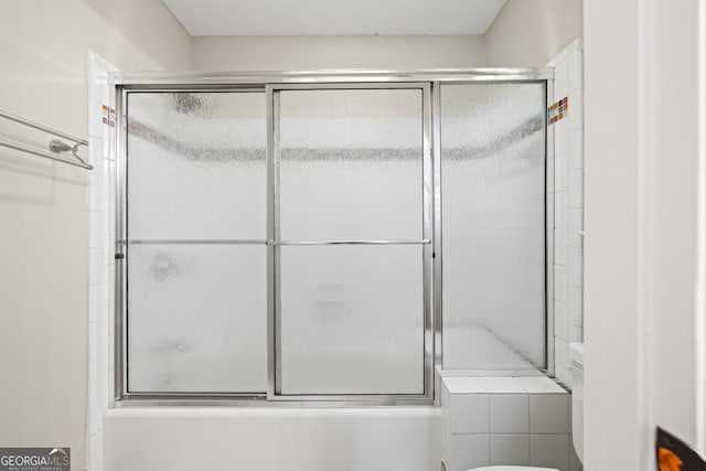 bathroom featuring toilet and enclosed tub / shower combo