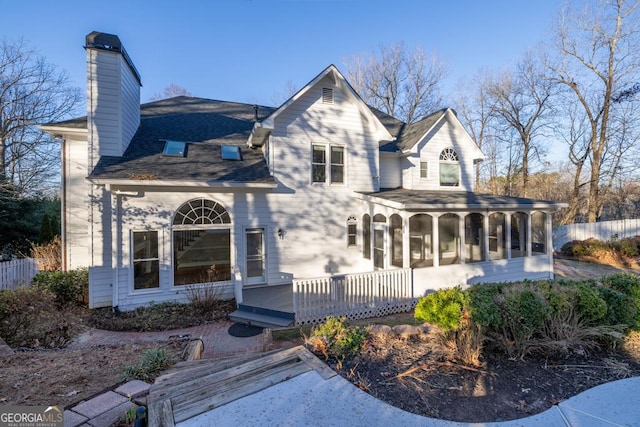 view of front facade featuring a sunroom and a wooden deck