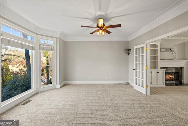 unfurnished room featuring carpet flooring, a wealth of natural light, crown molding, and ceiling fan